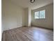 Bright bedroom with light-colored walls and hardwood flooring, featuring a window and modern ceiling light at 1812 Ashborough Se Cir # C, Marietta, GA 30067