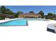 A large community pool with bright blue water is surrounded by lounge chairs and bordered by a clubhouse at 1812 Ashborough Se Cir # C, Marietta, GA 30067