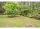 Lush backyard with mature trees and vibrant greenery creates a private and serene outdoor space at 2212 Chestnut Log Loop, Lithia Springs, GA 30122