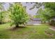 Expansive backyard featuring lush greenery, a concrete patio, and views of the home's light siding at 2212 Chestnut Log Loop, Lithia Springs, GA 30122