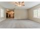 Living room with carpeted floors, an open layout to the kitchen, and large windows at 2212 Chestnut Log Loop, Lithia Springs, GA 30122