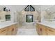 Bright, modern bathroom featuring double sinks, tub under window, and marble accents at 4978 Thornwood Nw Cv, Acworth, GA 30102