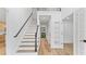 Bright foyer featuring hardwood floors, staircase with dark handrail, and a view to the upper level at 4978 Thornwood Nw Cv, Acworth, GA 30102