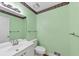 Powder room featuring a vanity with sink, toilet, and a mirrored wall against pastel-green paint at 509 Orchards Walk, Stone Mountain, GA 30087