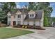Well-maintained two-story home featuring a lush lawn, mature trees, and a long, paved driveway at 509 Orchards Walk, Stone Mountain, GA 30087