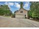 Home's side and garage, featuring a concrete driveway and lush green surroundings with trees at 509 Orchards Walk, Stone Mountain, GA 30087