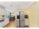 Open-concept kitchen and dining area features a stainless steel refrigerator, white cabinets, and granite counters at 509 Orchards Walk, Stone Mountain, GA 30087