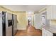 Bright kitchen boasts stainless steel fridge, granite countertops, yellow walls, and hardwood floors throughout at 509 Orchards Walk, Stone Mountain, GA 30087