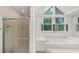 Spa-like main bathroom featuring glass shower, jacuzzi tub, and large window at 509 Orchards Walk, Stone Mountain, GA 30087