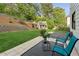 Spacious backyard featuring a stone retaining wall, lush green grass, and a charming playhouse at 230 Bluff Oak Dr, Roswell, GA 30076