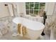 Bathroom featuring a soaking tub with marble-style tiles, and views of the backyard at 230 Bluff Oak Dr, Roswell, GA 30076