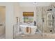 Bright bathroom features a soaking tub, walk-in shower, modern fixtures, and stylish finishes at 230 Bluff Oak Dr, Roswell, GA 30076