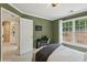 Comfortable bedroom featuring natural light, neutral carpet, olive colored walls and a small desk near a window at 230 Bluff Oak Dr, Roswell, GA 30076
