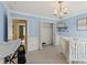 Bright Bedroom with blue walls and white trim, featuring a crib and access to another room at 230 Bluff Oak Dr, Roswell, GA 30076