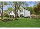 Charming two-story white home with black trim, lush lawn, and manicured landscaping at 230 Bluff Oak Dr, Roswell, GA 30076