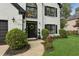 Inviting home entrance with a black door, lovely landscaping, and decorative black outdoor lights at 230 Bluff Oak Dr, Roswell, GA 30076