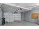 Spacious two-car garage with concrete floor, storage shelves, and an automatic door opener at 230 Bluff Oak Dr, Roswell, GA 30076