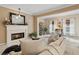 Bright and airy living room featuring a fireplace, view to a home office, and neutral furniture at 230 Bluff Oak Dr, Roswell, GA 30076