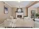 Cozy living room features a white fireplace, neutral paint, and an adjacent view to the dining room at 230 Bluff Oak Dr, Roswell, GA 30076