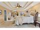 Bright main bedroom with tray ceiling, sitting area, large bed, and ensuite bathroom at 230 Bluff Oak Dr, Roswell, GA 30076
