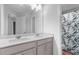 Bright bathroom with a double sink vanity, granite countertop, and a leaf patterned shower curtain at 4238 Linworth Blvd, Austell, GA 30106