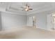 Spacious primary bedroom with neutral carpet, ceiling fan, and tray ceiling at 4238 Linworth Blvd, Austell, GA 30106