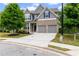 Charming two-story home featuring a brick facade, gray siding, two-car garage, and a well-manicured front yard at 4238 Linworth Blvd, Austell, GA 30106