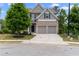 Charming two-story home featuring a brick facade, gray siding, two-car garage, and a well-manicured front yard at 4238 Linworth Blvd, Austell, GA 30106