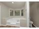 Soaking tub with windows bringing natural light into the bathroom at 565 Lake Joyce Ln, Fairburn, GA 30213