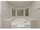 Soaking tub with windows bringing natural light into the bathroom at 565 Lake Joyce Ln, Fairburn, GA 30213