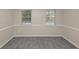 A bedroom featuring neutral walls, gray carpet, and two windows letting in plenty of light at 565 Lake Joyce Ln, Fairburn, GA 30213