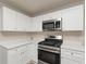 Updated kitchen features sleek, white cabinets, stainless steel appliances, and modern countertops at 565 Lake Joyce Ln, Fairburn, GA 30213
