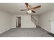 Cozy living room with gray carpet, ceiling fan, fireplace, and easy access to the staircase at 565 Lake Joyce Ln, Fairburn, GA 30213