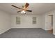 A spacious main bedroom with gray carpet, ceiling fan, and a doorway to the bathroom at 565 Lake Joyce Ln, Fairburn, GA 30213