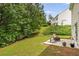 Landscaped backyard featuring a patio with chairs and a fire pit, surrounded by mature trees at 10204 Deep Creek Pl, Union City, GA 30291