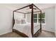 Bedroom with dark wood four poster bed frame, natural light, and carpeted floors at 10204 Deep Creek Pl, Union City, GA 30291