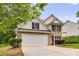 Traditional home showcasing a combination of brick and siding, with a spacious driveway and verdant landscaping at 10204 Deep Creek Pl, Union City, GA 30291