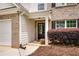 Inviting front entrance featuring brick accents, complemented by a covered porch, a black door and landscaped garden at 10204 Deep Creek Pl, Union City, GA 30291
