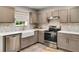 Well-lit kitchen featuring a farmhouse sink, stainless steel appliances, and stylish tile backsplash at 10204 Deep Creek Pl, Union City, GA 30291