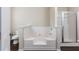 Bright bathroom featuring a tub with white tile surround and a glass-enclosed shower at 1646 Sandy Beach Point, Lawrenceville, GA 30043