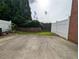 Backyard with concrete patio, green lawn, fence, and partial brick wall at 2656 Gadsen Walk, Duluth, GA 30097