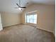 Spacious bedroom with neutral carpet, ceiling fan, and large window allowing ample natural light at 2656 Gadsen Walk, Duluth, GA 30097