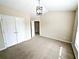 Bright bedroom with vaulted ceiling, carpet flooring, closet, and a modern light fixture at 2656 Gadsen Walk, Duluth, GA 30097