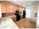 Well-lit kitchen features wood cabinets, modern appliances, and hardwood flooring at 2656 Gadsen Walk, Duluth, GA 30097
