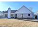 Home back exterior with brick, a manicured lawn, and fenced perimeter at 609 Grand Ashbury Ln, Buford, GA 30518