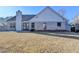 View of the rear of the home featuring a spacious backyard and neutral brick exterior at 609 Grand Ashbury Ln, Buford, GA 30518