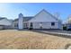View of the rear of the home featuring a spacious backyard and neutral brick exterior at 609 Grand Ashbury Ln, Buford, GA 30518