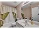 Bathroom with shower and tub featuring decorative curtains, bright vanity, and large mirror at 609 Grand Ashbury Ln, Buford, GA 30518