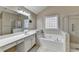 Bright bathroom with a soaking tub, tiled shower, and vanity with ample counter space at 609 Grand Ashbury Ln, Buford, GA 30518