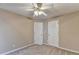 Neutral bedroom featuring light-colored carpet, a ceiling fan with lighting, and two white doors at 609 Grand Ashbury Ln, Buford, GA 30518